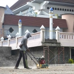 Salah seorang pekerja saat beraktivitas di depan Masjid An-Nur, Pare. 