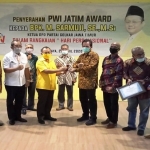 Ketua PWI Jatim Ainur Rohim didampingi pengurus lainnya menyerahkan PWI Jatim Award kepada Ketua DPD Partai Golkar Jatim,  H. Muhammad Sarmuji, S.E., M.Si, Kamis (23/4/2020). 