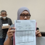 Indri Tri Wahyuni, nasabah BRI yang kehilangan uang Rp177 juta saat menunjukkan bukti transaksi. Foto: MUJI HARJITA/ BANGSAONLINE