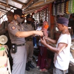 Petugas Satpol PP Kabupaten Kediri saat memberi imbauan kepada penjual dan pembeli di pasar tradional, untuk menerapkan prokes. (foto: kominfo)