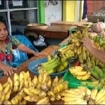 Sumarti, penyandang disabilitas asal Pacitan yang sukses merintis usaha karangan bunga sedang melayani penbeli pada lapak buah di teras rumahnya.