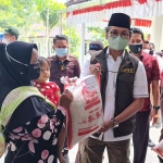 Bupati Bangkalan R. Abdul Latif Amin saat menyerahkan bantuan sosial beras (BSB) PPKM kepada perwakilan KPM PKH.