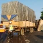 Truk gandeng muatan kayu triplek yang terguling dilintasan doubel. (Haris/BANGSAONLINE)