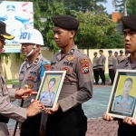 Kapolres Probolinggo, AKBP Wisnu Wardana, saat mencoret foto anggota sebagai simbol penghapusan atau pemecatan.