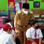 Bupati Trenggalek Nur Arifin saat meninjau pelaksanaan vaksinasi siswa anak di SDN 2 Surodakan, Trenggalek. foto: HERMAN/ BANGSAONLINE