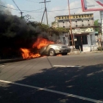 Mobil yang terbakar di simpang tiga Jl Raya Sembung, Kecamatan Perak, Kabupaten Jombang, Minggu (11/6/2017). foto: ROMZA/ BANGSAONLINE