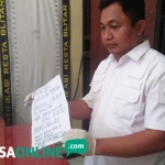 Petugas menunjukkan salah satu surat yang ditinggalkan korban. foto: AKINA/ BANGSAONLINE