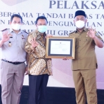 Bupati Gresik, Fandi Akhmad Yani, saat menerima penghargaan dari Kanwil ATR/BPN Jatim. Foto: SYUHUD/ BANGSAONLINE