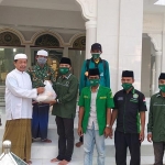 M. Amir, Koordinator Lapangan saat menyerahkan sembako kepada salah satu pengurus masjid di Kecamatan Klampis, Rabu (6/5/2020).