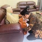 Ibunda Mahfud MD, Siti Khotijah, duduk di kursi. Firman Syah Ali, keponakan Menko Polhukam Mahud MD sungkem. foto: istimewa/ bangsaonline.com