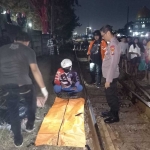 Jenazah korban saat dievakuasi oleh petugas kepolisian setelah nekat melindaskan tubuhnya di perlintasan KA di Utara Pasar Waru, Sidoarjo, Minggu (26/2/2024).