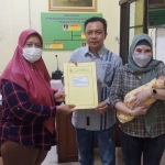 Wabup Blitar Rahmat Santoso menunjukkan dokumen adopsi anak didampingi sang istri (menggendong bayi).