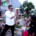 Pj Wali Kota Mojokerto Ali Kuncoro saat ngobrol dengan pemilik rumah yang roboh akibat plengsengan ambrol.