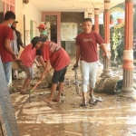 Suasana saat santri dari Pondok Pesantren Ar Rosyid Bangsalsari, Jember, membersihkan sisa banjir dan longsor.