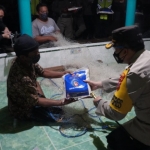 Kapolres Gresik AKBP Arief Fitrianto saat membagikan beras kepada nelayan.