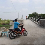 Pengendara sepeda motor melintasi jembatan di Desa Klurak, Kecamatan Candi, Sidoarjo. Foto: Ist