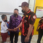 Wakil MPC Pemuda Pancasila Sidoarjo, Andry Harmoko, memberikan bingkisan dan beasiswa kepada Fadil.