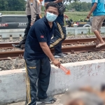 Petugas saat mengevakuasi korban tewas ditabrak kereta api di Jombang.
