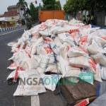 Ratusan Karung beras bulog yang tumpah di tengah jalan. foto: RONY SUHARTOMO/ BANGSAONLINE