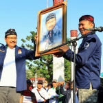 Wali Kota Pasuruan Saifullah Yusuf (kiri) menerima cenderamata berupa karikatur sebelum memberangkatkan parade sepeda tua.