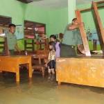 DILIBURKAN: Anggota Koramil Sidoarjo membantu menata bangku di SDN Sidokare 2 Kelurahan Sidokare Kecamatan Kota Sidoarjo, agar tidak terendam banjir, Senin (10/10). foto istimewa