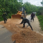 Anggota TNI Koramil Bancar bersama warga saat memperbaiki jalan penguhubung Kecamatan Bancar dan Jatirogo, Kabupaten Tuban, yang dipenuhi lubang.