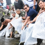 Direktur Utama SIG Donny Arsal (tengah) melepas ikan bilih di Danau Singkarak, Sumatra Barat. Foto: Ist.