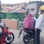 Warga yang keluar masuk Desa Karangrejo Kecamatan Manyar Gresik dilakukan pemeriksaan ketat sesuai protokol COVID-19. (foto: ist/ bangsaonline.com)