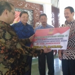 Pj Bupati Pamekasan Fattah Jasin saat menerima bantuan dana penanggulangan bencana dari Kementerian Sosial. 
