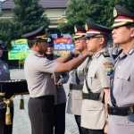 Kapolresta Sidoarjo Kombes Pol. Sumardji memimpin sertijab dengan memasangkan tanda pangkat jabatan dari pejabat lama kepada pejabat baru.