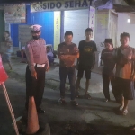 Petugas menunjukkan lubang jalan di sekitar Pasar Nglegok yang jadi penyebab kecelakaan.