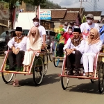 Arifin-Syah naik becak didampingi istri masing-masing. (foto: HERMAN/ BANGSAONLINE)