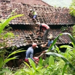 Warga bergotong royong memperbaiki rumah Marsus yang terkena tanah retak.