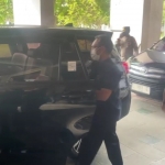 Penyidik KPK saat memasukkan koper ke dalam mobil setelah melakukan penggeledahan di kantor Pemkab Bangkalan.