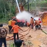 Petugas saat berupaya memadamkan semburan api dari sumur bor di Desa Kadur, Kecamatan Kadur, Kabupaten Pamekasan.