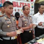 Kapolres Blitar AKBP Slamet Waloya (tengah) menunjukkan sejumlah barang bukti ungkap kasus pemalsuan STNK dan BPKB. foto: AKINA/ BANGSAONLINE