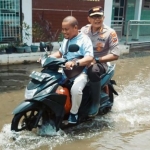 Kapolresta Sidoarjo Kombes Pol Sumardji dibonceng wartawan BANGSAONLINE.com, Catur Andy Erlambang saat meninjau banjir beberapa waktu lalu.