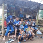 Anak-anak memanfaatkan taman baca Sungai Kedung dengan membaca buku-buku yang tersedia.