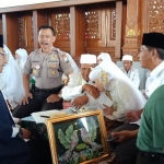 Sejumlah pasangan saat mengikuti nikah massal di Pendopo Krido Manunggal Tuban. Tampak pengantin pria yang sudah berumur sedang dicium tangannya oleh mempelai wanitanya.