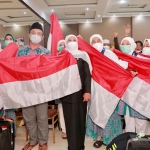 Gubernur Jawa Timur Khofifah Indar Parawansa menyambut kedatangan jemaah haji sekaligus membagikan bendera merah putih.
