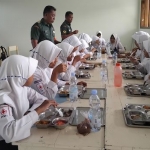 Para siswa SMPN 5 Kota Madiun saat menikmati paket Makan Bergizi Gratis. Foto: Hendro Suhartono/BANGSAONLINE