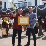 Kabid Humas PT Gudang Garam Tbk Iwhan Tricahyono (kiri) dan Humas PT. GG Eddy Staf saat menunjukkan piagam penghargaan dari Pemkot Surabaya. Foto: Ist.
