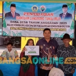 Kepala Desa Pelemwatu, Sukayin, saat menyalurkan BLT. Foto: SYUHUD/BANGSAONLINE