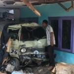 Kondisi mobil Daihatsu Hijet 1000 yang ringsek setelah dihantam truk dan rumah yang juga ambrol temboknya. foto : nanang ichwan/BANGSAONLINE