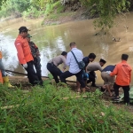 Petugas saat mengevakuasi jenazah di Sungai Pancir Jombang.