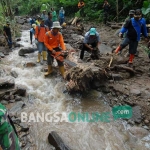 Upaya pembersihan jalur aliran sungai Dusun Pengajaran dari sisa-sisa kayu dan bebatuan yang terbawa banjir. foto: RONY SUHARTOMO/ BANGSAONLINE