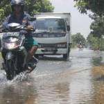 LANGGANAN: Genangan air di jalan poros Kecamatan Plumpang dari tahun ke tahun semakin parah. foto: suwandi/ BANGSAONLINE