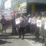 Kapolres Pasuruan bersama Banser dan relawan, membagikan paket sembako bagi warga yang terdampak Covid-19 di sekitar Plaza Bangil.
