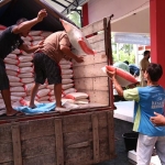 Beras untuk warga terdampak Covid-19 saat diturunkan dari truk. (foto: Kominfo).