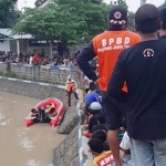 Anggota BPBD Jombang sedang melakukan pencarian korban tenggelam.